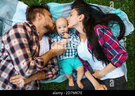 Madre e padre che baciano il loro bambino, vista dall'alto Foto Stock