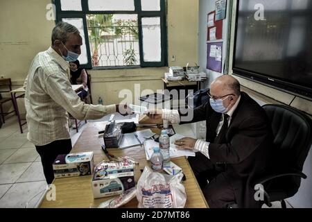 Giza, Egitto. 24 Ott 2020. Un uomo si registra prima di votare all'interno di un seggio nel distretto di al Omrania durante il primo turno della prima fase delle elezioni parlamentari egiziane. Credit: Sayed Hassan/dpa/Alamy Live News Foto Stock