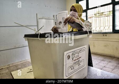 Giza, Egitto. 24 Ott 2020. Una donna lancia il suo voto in una casella elettorale all'interno di una stazione elettorale del distretto di al Omrania durante il primo turno della prima fase delle elezioni parlamentari egiziane. Credit: Sayed Hassan/dpa/Alamy Live News Foto Stock