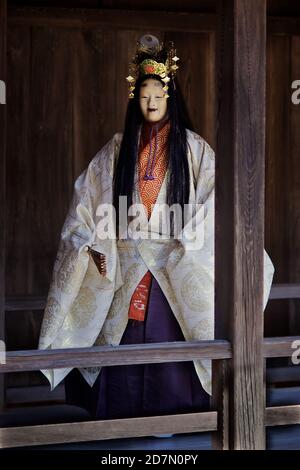 Gli attori che indossano la maschera e lo scivolo tornano dal palcoscenico al Santuario di Itsukushima sull'isola di Miyajima, Hiroshima Ken, Seto Inland Sea, Giappone 2012. Nô Foto Stock