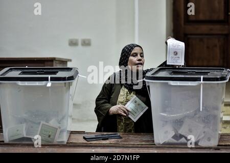 Giza, Egitto. 24 Ott 2020. Una donna lancia il suo voto in una casella elettorale all'interno di una stazione elettorale nel distretto di Dokki durante il primo turno della prima fase delle elezioni parlamentari egiziane. Credit: Sayed Hassan/dpa/Alamy Live News Foto Stock