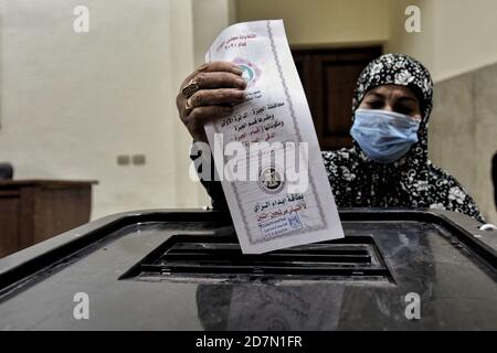 Giza, Egitto. 24 Ott 2020. Una donna lancia il suo voto in una casella elettorale all'interno di una stazione elettorale nel distretto di Dokki durante il primo turno della prima fase delle elezioni parlamentari egiziane. Credit: Sayed Hassan/dpa/Alamy Live News Foto Stock