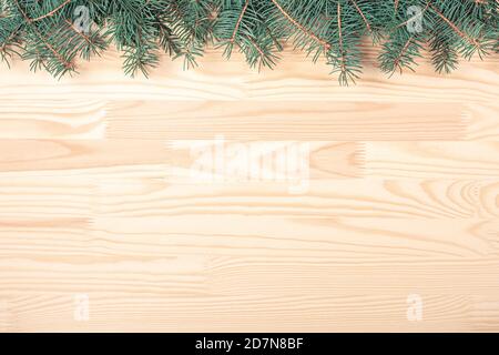 rami di abete su uno sfondo di legno chiaro. molto spazio per il testo di saluto allegro natale e felice anno nuovo. cartolina di natale Foto Stock