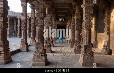 New Delhi, 22, Marzo, 2017:Portico con i turisti sotto colonne di pietra scolpite dal complesso Qutub conosciuto come Patrimonio Mondiale dell'UNESCO, Nuova Delhi, India Foto Stock