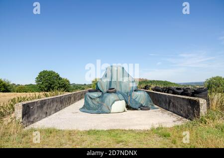 Pila o pila di balle di fieno e scartato vecchia gomma Pneumatici in campagna in Germania Foto Stock