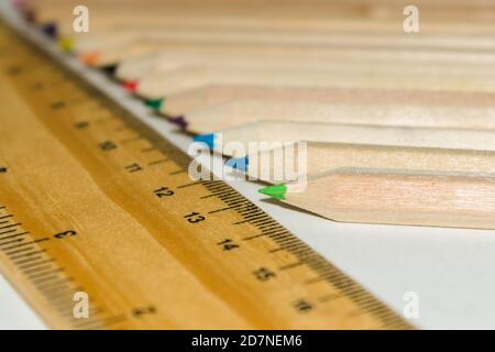 Matita a forma esagonale colore e righello in legno su fondo bianco isolato. Foto Stock