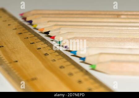 Matita a forma esagonale colore e righello in legno su fondo bianco isolato. Foto Stock