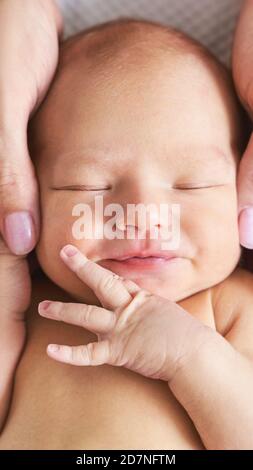 Testa piccola neonato. La madre tocca le piccole persone. Concetto di massaggio sanitario Foto Stock