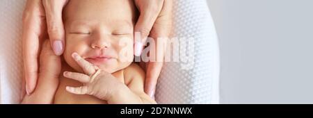 Testa piccola neonato. La madre tocca le piccole persone. Concetto di massaggio sanitario Foto Stock