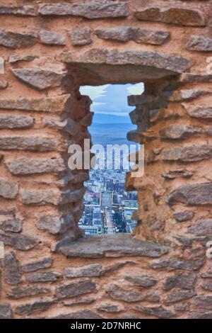 Una vista sulla città Deva attraverso una finestra fatta di rocce Foto Stock