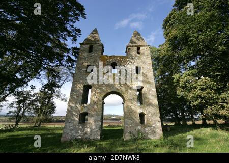 Confina con l'Hundy Mellerstain House nr Kelso. Hundy Mundy Tower, torre a Melrose, Scozia, Regno Unito. Una follia che prende il nome da una principessa che domina i corpi in un sito naturale di sepoltura boschiva. Una follia gotica costruita per completare la vista progettata che si estende a sud-est da Mellerstain nei confini scozzesi, Hundy Mundy occupa una posizione spettacolare un miglio (1,5 km) a nord-est di Smailholm e 5 miglia (8 km) a nord-ovest di Kelso. Iniziato nel 1726 e comprendente un'alta arcata tra torri quadrate, che sono tappate da piramidi, fu opera di William Adam (1689 - 1748) che era stato l'architetto Foto Stock