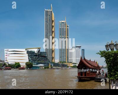 Fiume Chao Praya a Bangkok con l'icona del centro commerciale Siam e le torri di residenza sul fiume. Più in alto sul fiume, il Millenium Hilton è visibile. Foto Stock