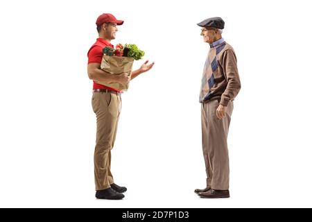 Foto di profilo a lunghezza intera di un tipo di consegna con un borsa della spesa che parla con un vecchio cliente maschile isolato sopra sfondo bianco Foto Stock