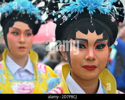 In costume, le donne thailandesi cinesi performer con la tradizionale maschera dipinta dell'opera di Pechino posano per la fotocamera alla colorata sfilata di strada di Capodanno cinese. Foto Stock