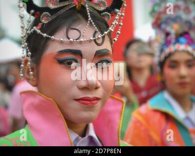 La performer tailandese cinese in costume con la maschera dipinta tradizionale dell'opera di Pechino si pone per la fotocamera alla colorata sfilata cinese di strada di Capodanno. Foto Stock