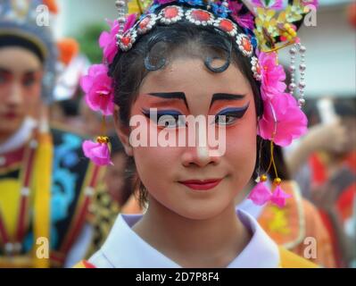 L'esecutore cinese tailandese in costume femminile con la maschera painted tradizionale dell'opera di Pechino pone per la macchina fotografica alla parata di strada di Capodanno cinese colorata. Foto Stock