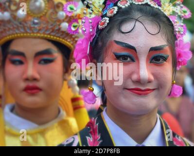 In costume le donne cinesi thailandesi con maschere dipinte dell'opera di Pechino tradizionale posano per la macchina fotografica alla variopinta sfilata di strada di Capodanno cinese. Foto Stock