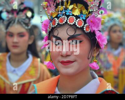 L'esecutore cinese tailandese in costume con la tradizionale maschera dell'opera di Pechino dipinta pone per la fotocamera alla colorata sfilata di strada di Capodanno cinese. Foto Stock