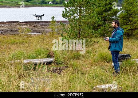 Pilota di droni dopo il decollo con un drone DJI nel Galloway Forest Park, Scozia - Regno unito - 15 settembre 2020 Foto Stock