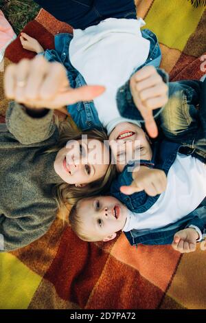 Una famiglia felice sta sorridendo e guardando in su. Famiglia in un picnic. Foto Stock