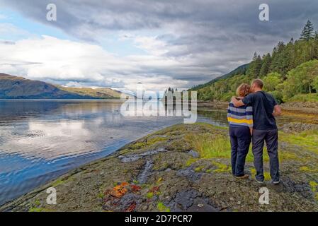 Coppia che gode la vista all'area picnic a Loch Linnhe nelle Highlands in un giorno d'autunno - costa occidentale Scozia - destinazione di viaggio - Fort William, High Foto Stock