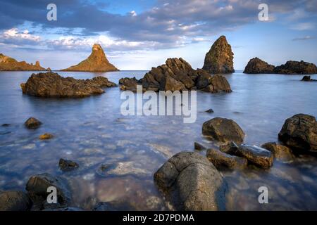 Isole Ciclopiche, Aci Trezza, Sicilia, Italia. Queste furono le grandi pietre gettate a Odysseus dal mostro Ciclope nel poema epico "l'odissea". Foto Stock