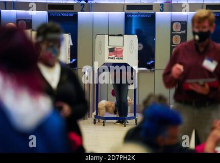 New York, Stati Uniti. 24 Ott 2020. Un elettore (C) compila lo scrutinio durante il voto di persona in anticipo ad una stazione di scrutinio in Madison Square Garden a New York, gli Stati Uniti, 24 ottobre 2020. Le prime votazioni sono iniziate in tutto lo Stato di New York sabato, offrendo agli elettori nove giorni per lanciare i voti prima della Giornata delle elezioni. Credit: Wang Ying/Xinhua/Alamy Live News Foto Stock