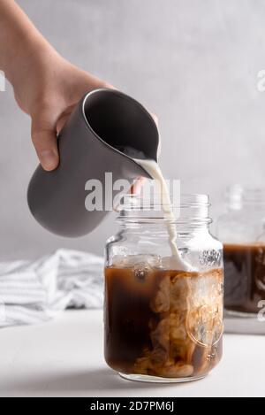 Colpo verticale di fare un latte di caffè in un vasetto Foto Stock