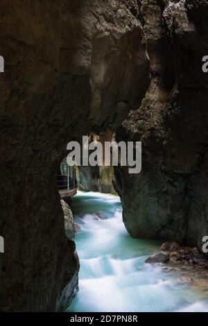 Un fiume di montagna pulito, bello scorre attraverso un grot roccioso Partnachklamm in Germania incisa da un torrente di montagna vicino al Garmisch-Partenkirchen Foto Stock