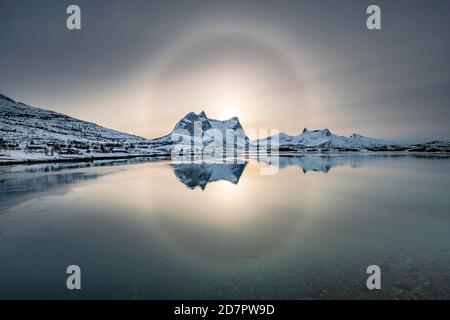 Anello del sole, alone su neve catena montuosa Kulhornet, artico paesaggio invernale, Koblenestinden, in fronte mare, Ballangen, Nordland, Norvegia Foto Stock