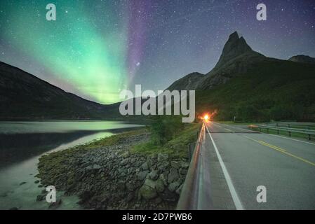 Ripresa notturna di (Aurora borealis) una strada con ingresso illuminato al tunnel, cielo stellato, aurora boreale, , nella montagna posteriore Foto Stock