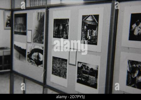 Fine anni '70 vintage nero e bianco fotografia di fotografia di opere d'arte esposti su una parete in una galleria d'arte in persona. Foto Stock