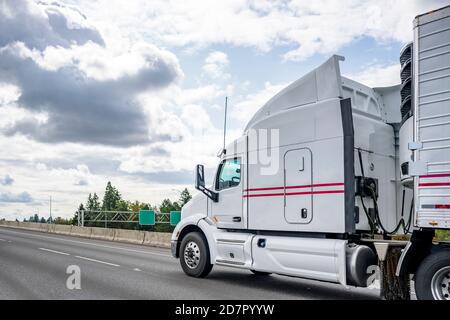 Industriale professionale Big RIG Classic diesel Long Haul bianco semi trattore per autocarri che trasporta carichi commerciali in un semirimorchio frigorifero in funzione f Foto Stock