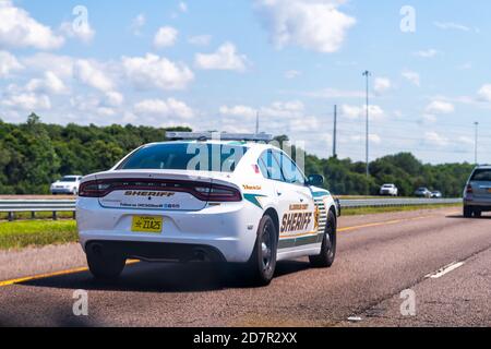 Gibsonton, USA - 27 aprile 2018: Florida strada statale vicino Tampa con traffico sceriffo auto segno di polizia in giornata di sole Foto Stock