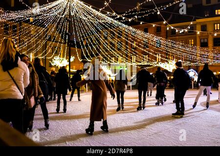 Varsavia, Polonia - 19 dicembre 2019: Piazza del mercato della città vecchia Warszawa di notte con decorazione di illuminazione di Natale, le persone che pattinano alla pista di pattinaggio Foto Stock