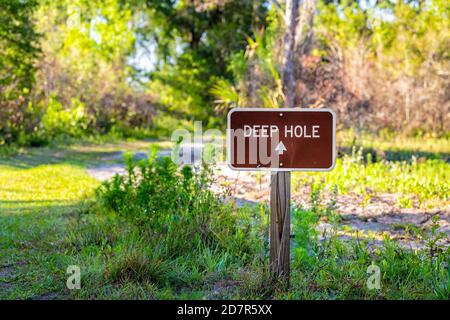 Segno closeup a profondo buco Sinkhole sentiero escursionistico e nessuno Al parco statale del fiume Myakka a Sarasota, Florida Foto Stock