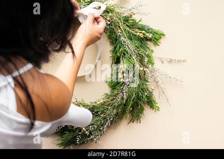 Carina donna decora la corona dell'avvento con le mani Foto Stock