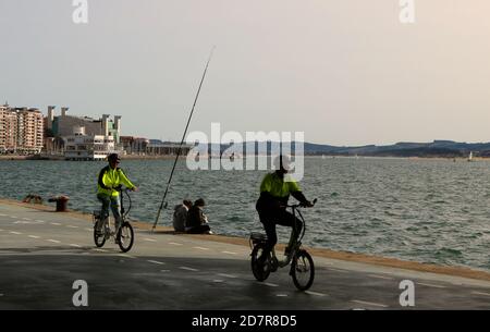 Ciclisti che percorrono il Paseo Maritimo de Santander Cantabria Spagna In una soleggiata mattina di ottobre all'ombra del Centro artistico Botin Foto Stock