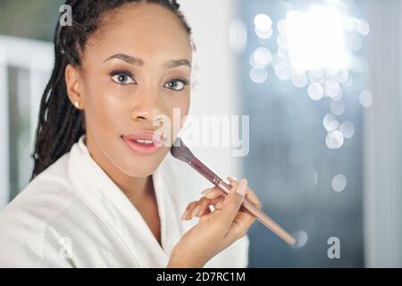 Donna l'applicazione di polvere per il viso Foto Stock