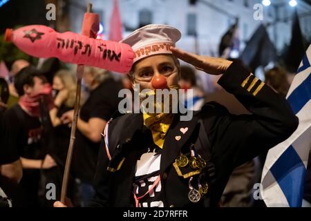 GERUSALEMME, ISRAELE - 24 OTTOBRE: Un protetore che indossa un costume da marinaio e un naso rosso di pagliaccio partecipa a una manifestazione di massa vicino alla residenza ufficiale del primo ministro il 24 ottobre 2020 a Gerusalemme, Israele. Gli organizzatori di protesta hanno dichiarato in una dichiarazione che 170,000 persone hanno manifestato contro il primo ministro Benjamin in tutto il paese chiedendo le sue dimissioni a causa della sua accusa di innesto e la gestione della pandemia COVID-19. Foto Stock