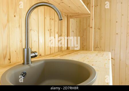 Lavello con un primo piano mixer in un set da cucina fatto di legno naturale Foto Stock