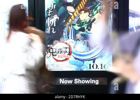 La gente passa accanto a un poster per un film animato basato sul popolare manga giapponese 'Demon Slayer: Kimetsu no Yaiba The Movie: Infinite Train' in mostra fuori da un cinema a Tokyo, Giappone, il 23 ottobre 2020. Credit: Naoki Nishimura/AFLO/Alamy Live News Foto Stock