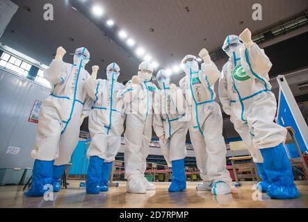 (201025) -- PECHINO, 25 ottobre 2020 (Xinhua) -- gli operatori sanitari posano per le foto dopo aver visto i pazienti curati fuori all'ospedale temporaneo di Wuchang a Wuhan, provincia di Hubei, Cina centrale, 10 marzo 2020. (Xinhua/Xiao Yijiu) Foto Stock