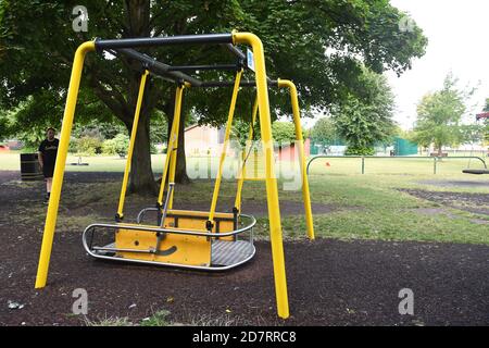 Sedia a rotelle Swing nell'area giochi per bambini, Victoria Park, Newbury, Berkshire, UK Foto Stock