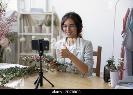 Sorridente fiorista femmina girare video decorazioni tutorial Foto Stock