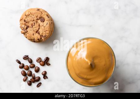 Caffè Dalgona con biscotti al cioccolato e chicchi di caffè su un tavolo di marmo. Vista dall'alto Foto Stock