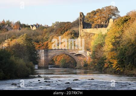 Il fiume Tees che scorre sotto il ponte della contea con le rovine del castello di Barnard illuminate da Late Evening Light in autunno, Teesdale, County Durham, Foto Stock