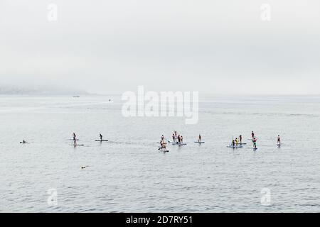 SANXENXO, SPAGNA - 26 AGOSTO 2020: Un gruppo di giovani si diverte a praticare il paddle surf nella Ria de Pontevedra in una giornata estiva. Foto Stock