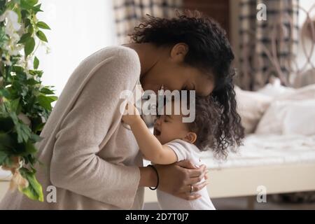 La mamma afro-americana ama giocare con il bambino Foto Stock