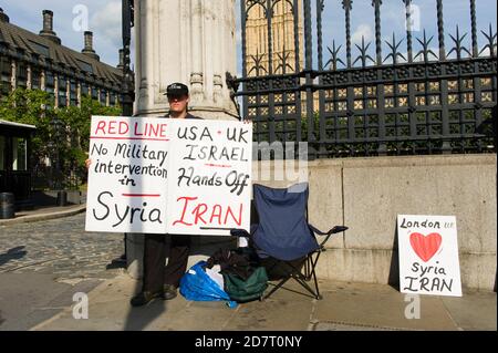 Manifestanti contro la Gran Bretagna che intraprenderà azioni militari contro la Siria, dopo gli attacchi chimici in Siria delle ultime settimane da parte del regime siriano, al di fuori del Parlamento, durante un dibattito parlamentare sulle azioni che la Gran Bretagna dovrebbe intraprendere contro Siria, Parlamento, Westminster, Londra, Regno Unito. 29 ago 2013 Foto Stock